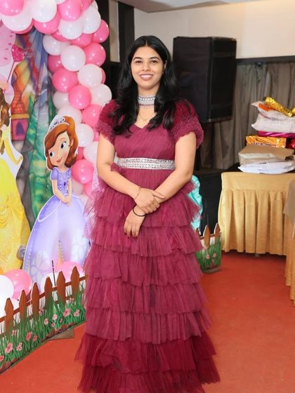 A client looking lovely in a tiered maroon gown at a birthday party. It's a comfortable yet stylish option for any family function.