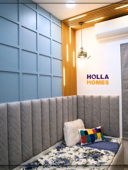 The cozy bed area in this boy's room features a plush, channel-tufted headboard and a feature wall with blue wainscoting, creating a comfortable and stylish space.