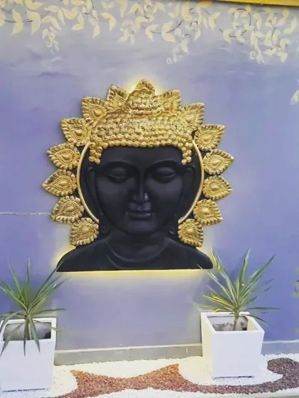 A magnificent backlit Buddha wall art piece with a golden halo, creating a divine and powerful statement on this terrace wall.