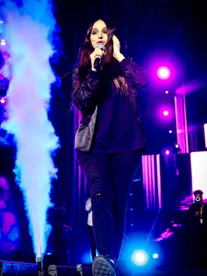 Lana Rose commanding the stage with a column of blue smoke beside her. Special effects like smoke and cryo jets make for incredible, high-energy concert photos.