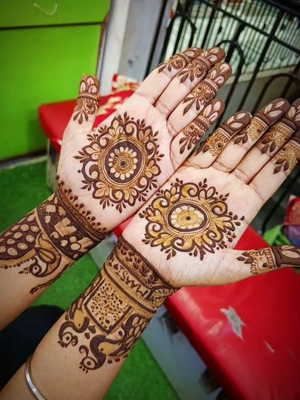 A unique design with a central mandala on each palm. One hand features a peacock eye motif, while the other has a classic floral mandala, showing how two different styles can complement each other.