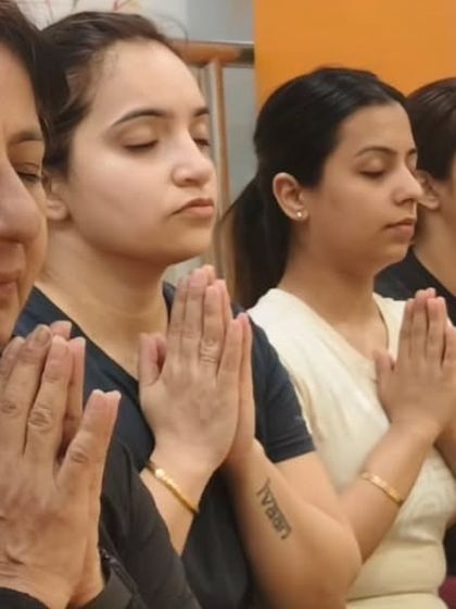 Hands in prayer, eyes closed, minds centered. This is a moment of shared intention and gratitude, a key part of our yoga practice that fosters inner peace.