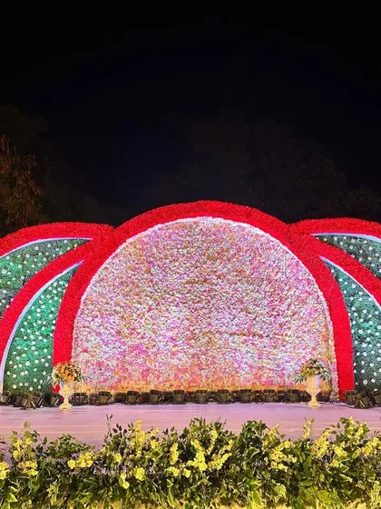 A slightly different angle of the colorful floral arch stage, showing the depth and texture of the flower arrangements.