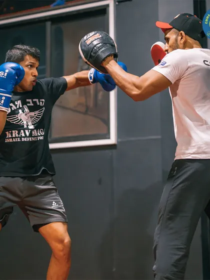 An MMA coach works one-on-one with a student on his punching technique. This personalized attention is a cornerstone of my training philosophy.