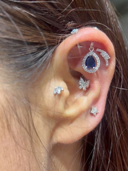 A delicate and whimsical ear stack. This look combines a deep blue teardrop hanging, butterfly studs, and a star stud for a touch of magic.