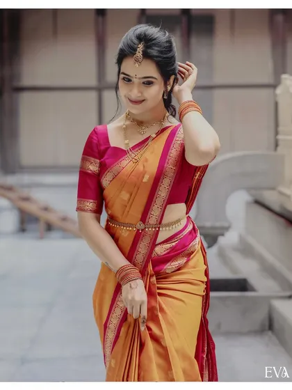 A bright and joyful portrait from a South Indian engagement ceremony. The bride-to-be, dressed in a vibrant yellow and pink silk saree, embodies the happiness of the occasion, showing our ability to capture authentic moments in event photography.