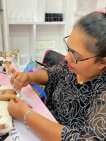 A student carefully files a client's nails, demonstrating the precision and attention to detail we teach.