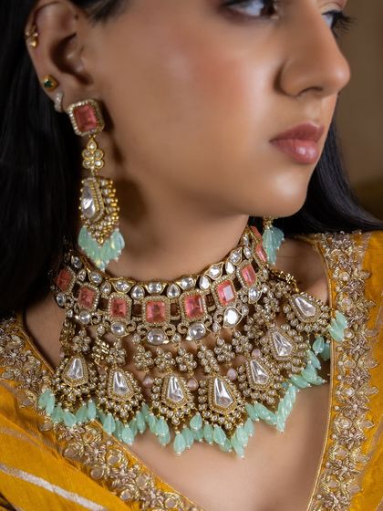 An ode to modern jewellery with pure craftsmanship. This Kundan necklace set blends subtle pink and mint hues, celebrating the luxury of Indian heritage with a contemporary twist.