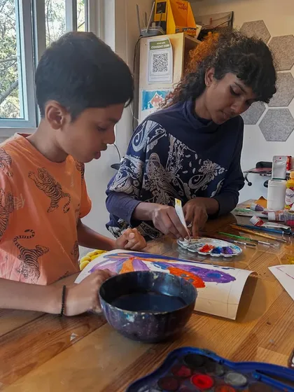Two students collaborate and learn from each other while working on their peacock paintings. Our group classes foster a sense of community and shared discovery.