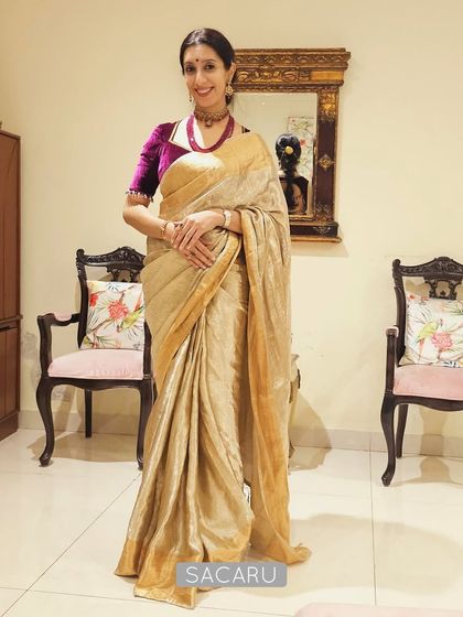 Our client Krupa looking poised in a full-length view, wearing a beautiful contrast velvet blouse with a shimmering gold saree.