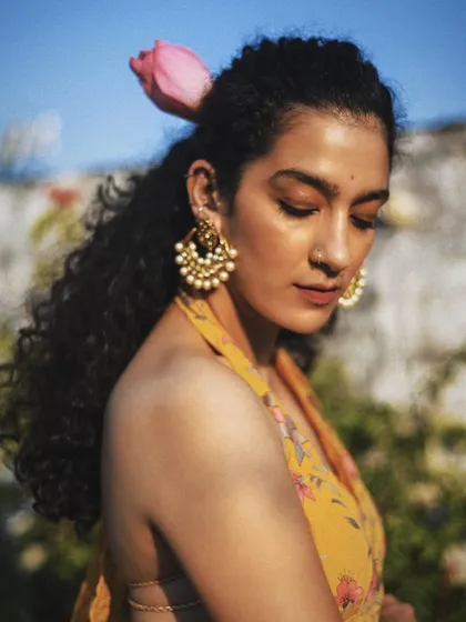 A beautiful portrait for the brand Baavli, with a flower tucked in the model's hair. The soft light and traditional attire create a romantic and festive mood.