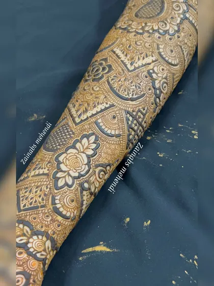 A detailed shot of the forearm portion of Musfira's bridal henna, highlighting the intricate rose and geometric work.