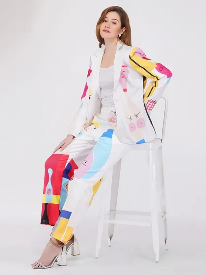 A model seated in a vibrant pantsuit, demonstrating a different pose for the same product to give customers a comprehensive view.