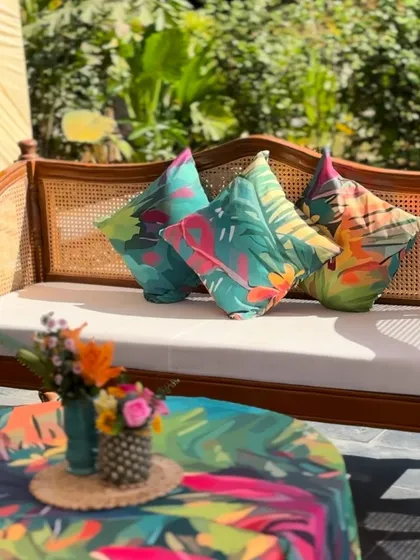 Custom-printed tropical cushions and table linens, designed to create a cohesive and vibrant theme for a poolside party.