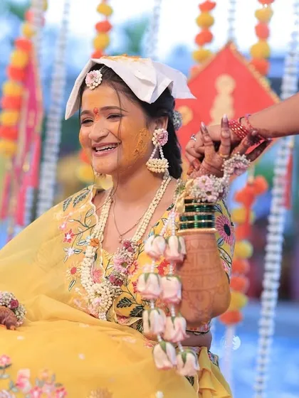 A candid moment from the Haldi ceremony, with a clear view of the floral kaliree being tied to the bride's bangles.