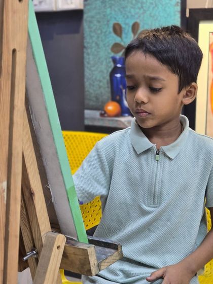 Another angle of our young student at his easel, showing the comfortable and encouraging environment we provide for artists of all ages.