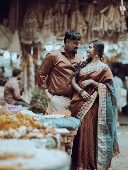 A vibrant and cultural shot capturing a candid moment between a couple in traditional attire at a bustling Bangalore flower market, highlighting a truly local love story.
