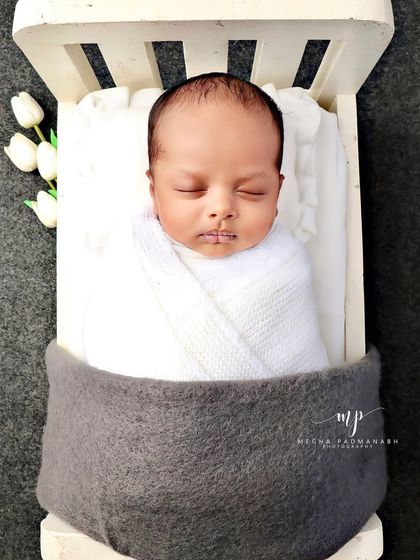 A top-down view of the baby in the bed, with small white tulips on the side.