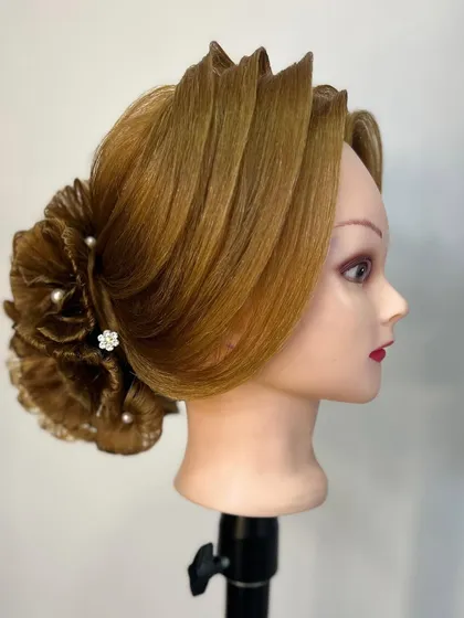 A side profile of the intricate floral hair bun, showing the detailed layering and shaping involved in its creation.