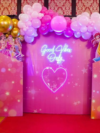 A "Good Vibes Only" neon sign and heart create a modern, fun photo booth for a princess party.
