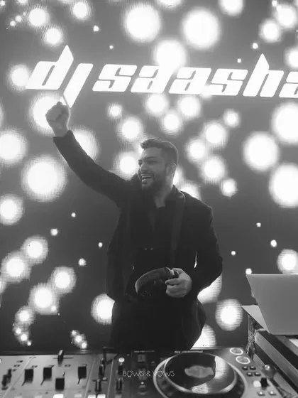 A moment of pure joy behind the decks. This black and white shot captures me in my element, with my logo lighting up the background. It's more than just playing music; it's about creating an unforgettable night.