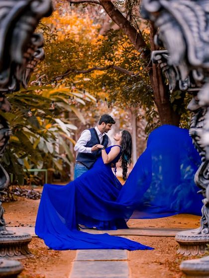 A creative shot framing the couple through ornate stone pillars, adding depth and an artistic touch to the pre-wedding photo.
