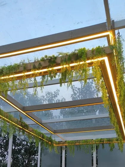 It's all about the vibe. Here, I added artificial creepers and warm LED strip lighting to a glass pergola, creating a dreamy and inviting atmosphere for the evening.