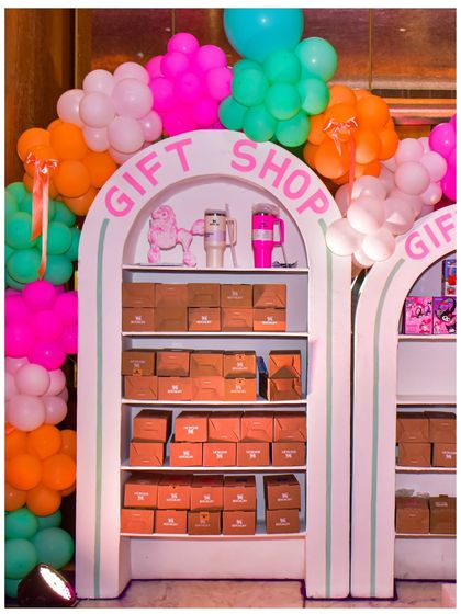The 'Gift Shop' at the Parisian party, where guests could pick up their party favours. The setup is framed by a colourful balloon garland.