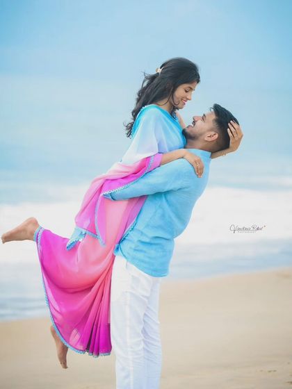 The beach provides a perfect canvas for romantic and playful couple portraits. This destination shoot captures a classic lift against the backdrop of the waves and open sky.