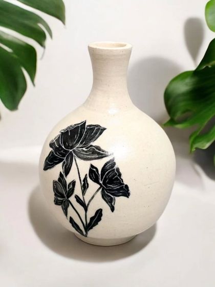 Enhance your interior design with the classic elegance of this hand-painted ceramic vase. The bold, black floral design makes it a unique and artistic enhancement for your home.