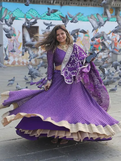 A joyful shot of the purple bandhani lehenga in motion. The traditional print combined with a modern silhouette makes it a versatile and beautiful choice.