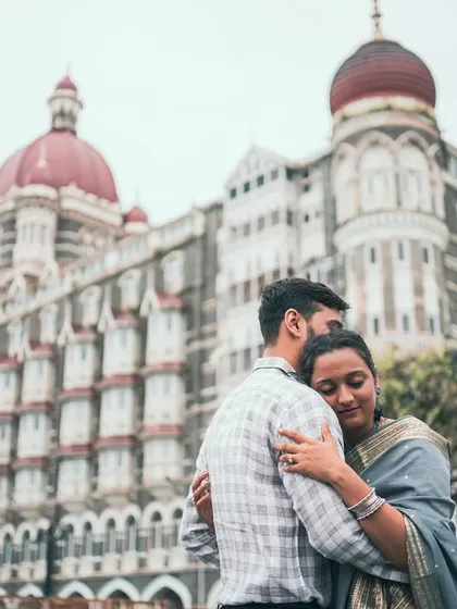 An intimate embrace with the iconic Taj Mahal Palace Hotel in the background. This photo blends a personal moment with a grand, historic Mumbai landmark.