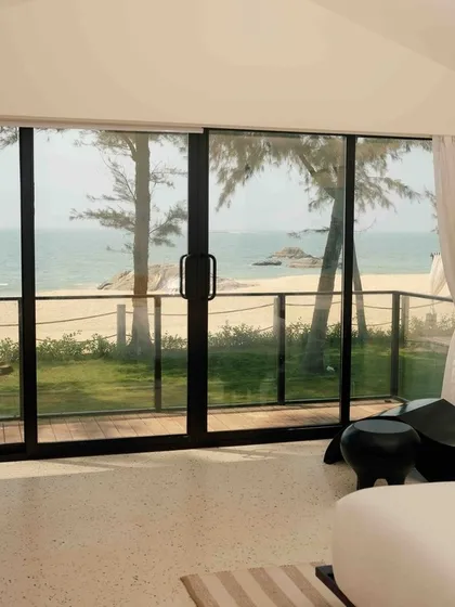 The bright and airy room at The Postcard Arabian Sea, with floor-to-ceiling windows that frame the perfect beach view.