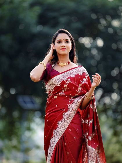 A lovely three-quarter portrait against a soft, out-of-focus background, making the red saree the star of the image.