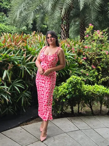 A full-length shot of the pink heart-print dress. The tie-shoulder straps and midi length make it a perfect choice for a brunch, a day out at the mall, or a cute date.