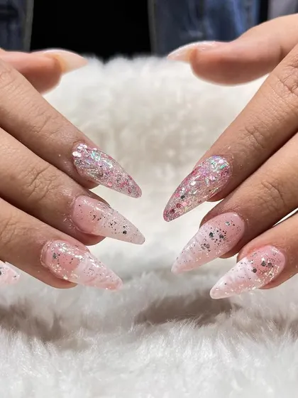 A sharp, stiletto nail set with glitter and inlay effects. We teach various nail shapes and how to create custom designs that cater to every client's style.