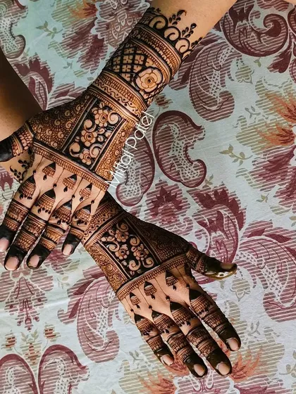 Another angle of the heavy Indian back-hand design, showing the symmetry and detail in the floral and geometric bands.