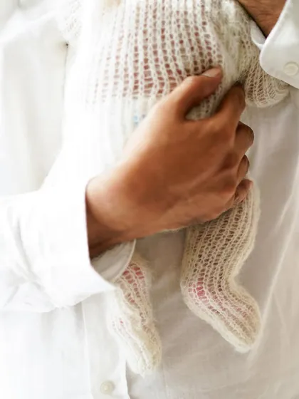 The secure and loving hold of a father's hand. We believe in capturing these small, intimate details that speak volumes about the bond you share with your new baby.