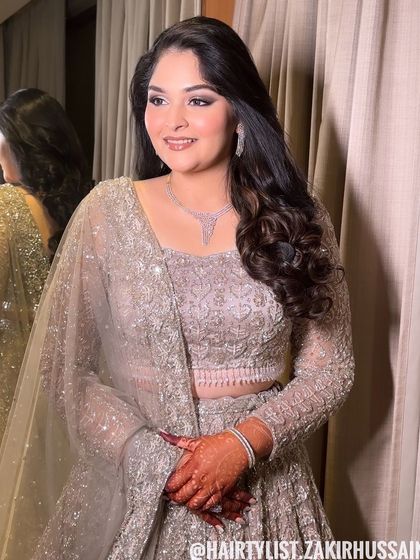 A classic open hairstyle with soft, side-swept waves. This is an elegant and understated look, perfect for an engagement or reception.