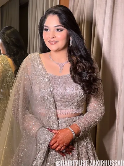 A classic open hairstyle with soft, side-swept waves. This is an elegant and understated look, perfect for an engagement or reception.