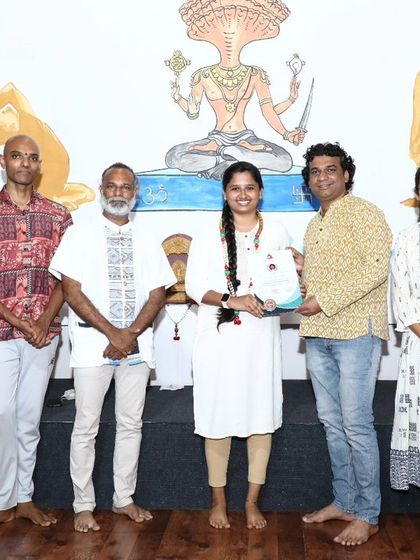 A student is awarded her certificate for the Singing Bowl and Sound Healing TTC, marking her achievement.