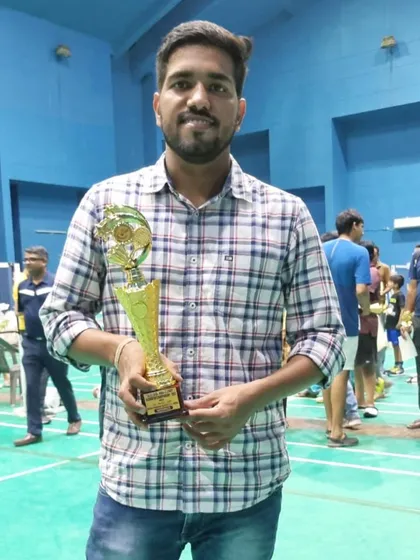 Mr. Mohit Hooda holding the winners' trophy after he and his partner secured first place in the Men's Doubles category at the Gautumbudh Nagar District Championship.