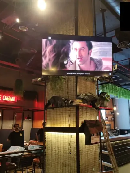 A TV display installed at BrewDog Gurugram, shown here playing a movie. Our installations ensure screens are securely mounted and positioned for optimal viewing, whether for sports, music videos, or ambient visuals.