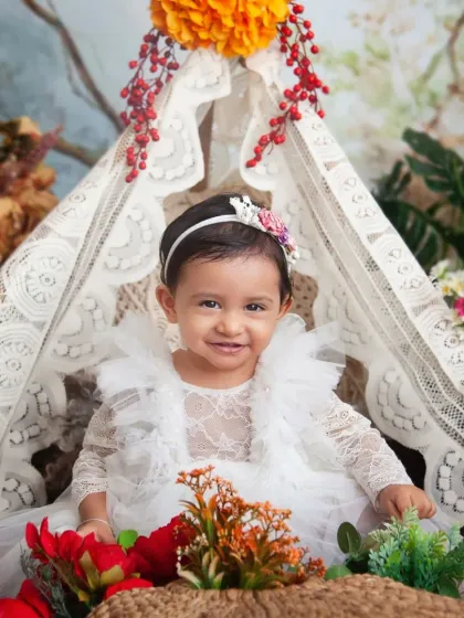 Her smile is as bright as the flowers around her. The lace teepee and colourful blooms create a beautiful boho-chic vibe.