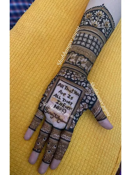 A clear shot of a personalized engagement mehndi. The design features a meaningful quote and the couple's hashtag, making it a modern and romantic choice.