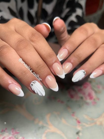 A clean and modern bridal design. This set combines classic French tips with accent nails featuring a sculpted white shell texture and a single rhinestone for a touch of sparkle.