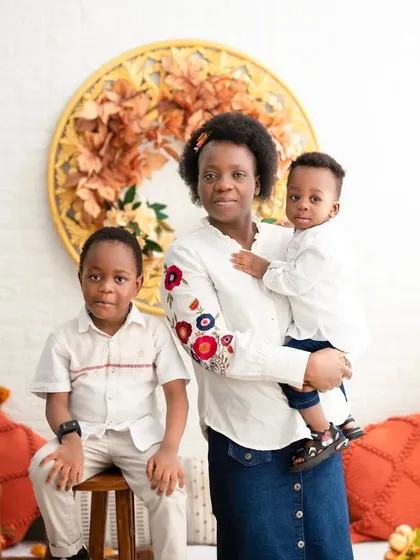 A mother with her two boys. This classic portrait showcases the bond between them in our warm, autumnal-themed studio setup.