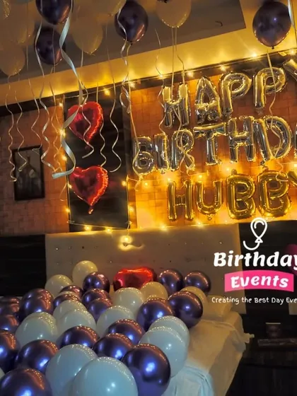 A special birthday surprise for a husband. This room decor features "Happy Birthday Hubby" in foil letters, with purple and white balloons filling the bed and heart-shaped foils for a romantic touch.