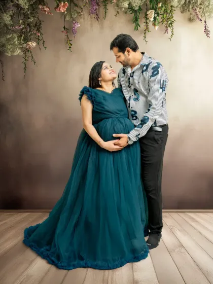 A sweet couple's moment during the gown session. The partner joins in, looking lovingly at the mom-to-be, adding a layer of connection and shared joy to the portrait.