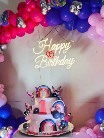 A close-up of the beautiful two-tier butterfly-themed cake, perfectly complementing the balloon decorations.